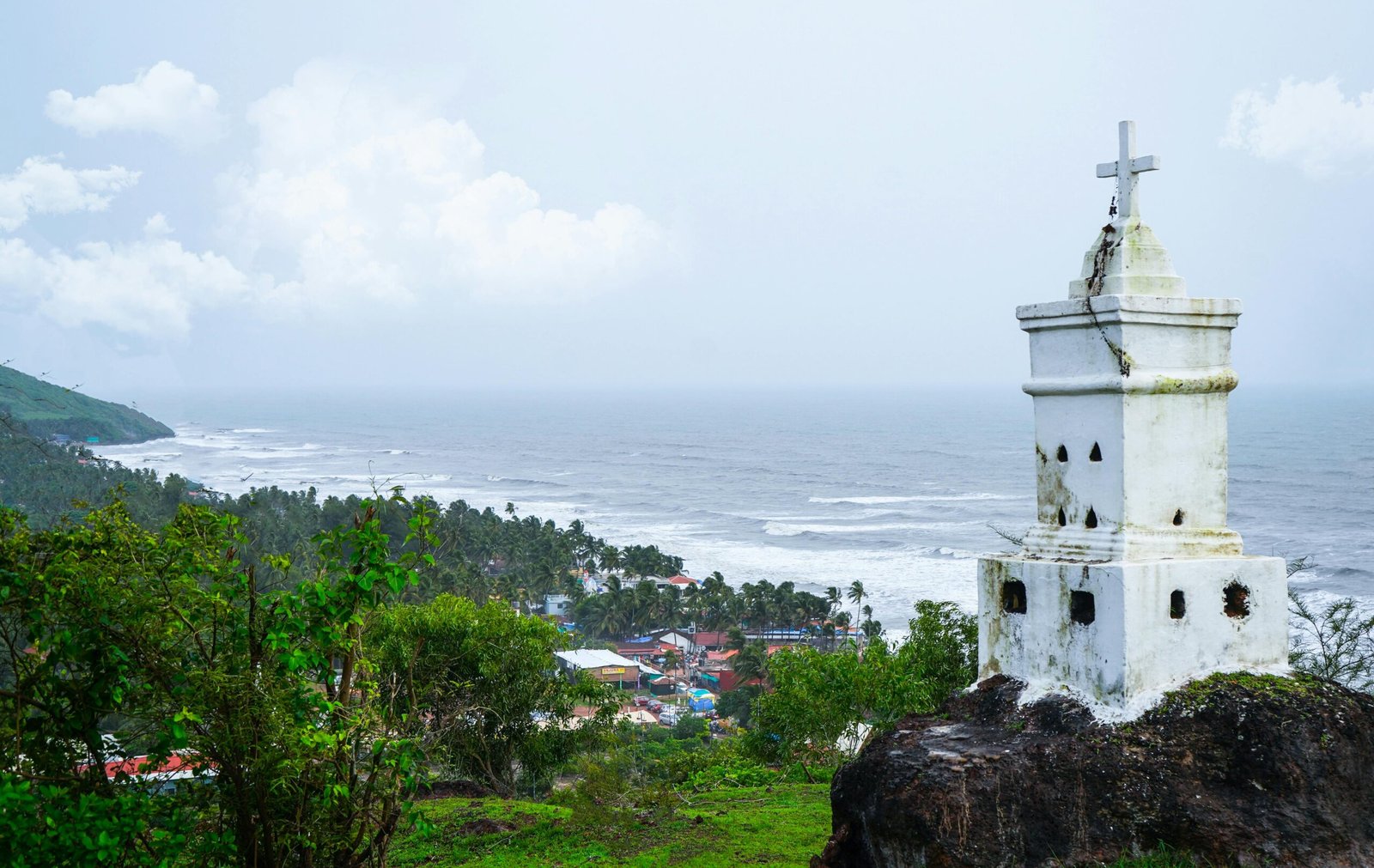 View of the Anjuna coast with a white monument in the foreground, capturing the beauty of Goa's seaside.