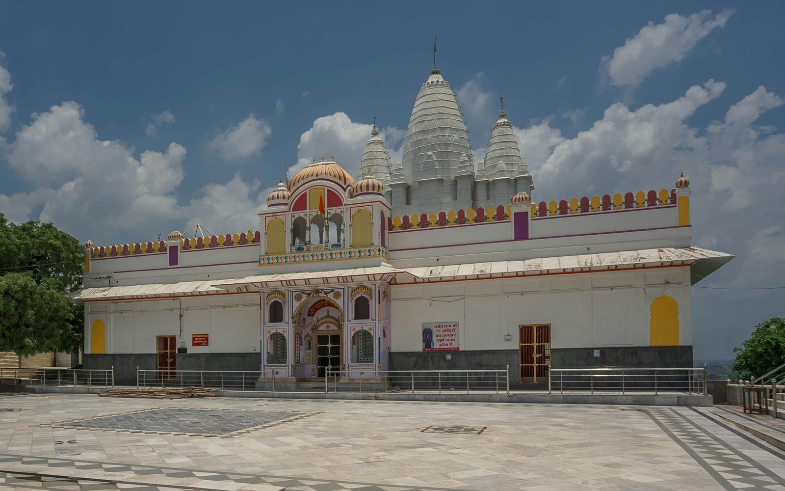 Beautiful temple architecture in Bhadona, showcasing vibrant colors against a blue sky.